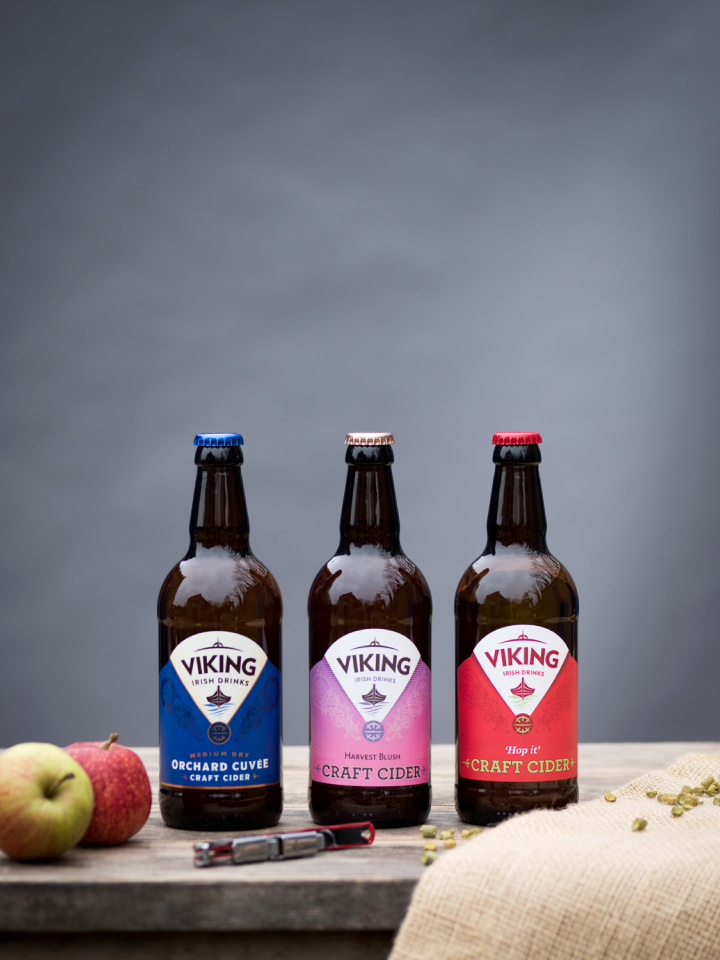 three bottles of craft apple cider on wooden table